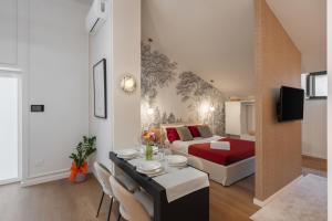 a room with a bed and a dining table in a room at Altrove Boutique Studios in Caserta