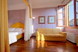 フィレンツェにあるMagic Signoria Apartmentのベッドルーム1室(ベッド1台、ソファ、窓付)