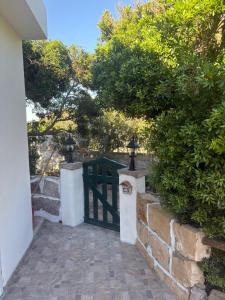 a entrance to a house with a gate and bushes at A Bugatta in Ìsola di San Pietro