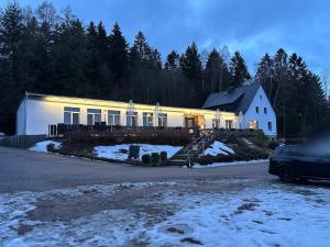 a house with a car parked in front of it at Pension und Berggasthaus Am Knochen in Geyer +6 photos