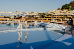 two women are standing in the pool at a resort at Vale Do Lobo Resort in Vale do Lobo
