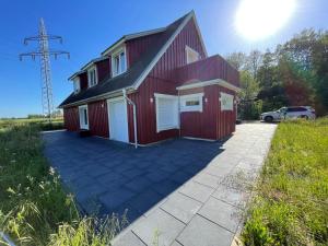 a red house with a driveway in front of it at Ferienhaus Calle in Bücken