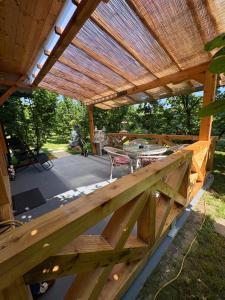 eine hölzerne Pergola mit Tisch und Terrasse in der Unterkunft Vikendica Harbaš in Cazin
