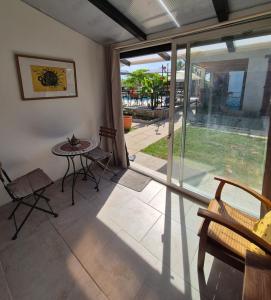 a room with a table and chairs and a sliding glass door at Le petit Riyade in Cambayrac
