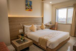 a bedroom with a bed and a table and a window at The RRA Kabras Hotel, Nathdwara in Nāthdwāra