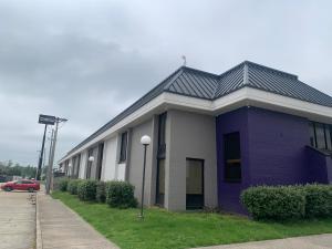 a purple building with a car parked in front of it at Mustang Inn in Paducah +4 photos