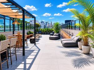 a patio with tables and chairs on a roof at Aurea Baulten by 123Quarto in Tambaú