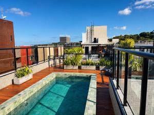 a balcony with a swimming pool on top of a building at Aurea Baulten by 123Quarto in Tambaú