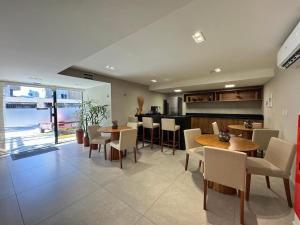 a kitchen and dining room with tables and chairs at Aurea Baulten by 123Quarto in Tambaú