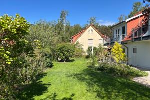 a yard with green grass and a house at Ruhige Auszeit zu zweit - Ferienwohnungen auf Usedom für Radfahrer & Strandliebhaber in Loddin