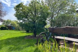 a bike parked next to a bench in a yard at Ruhige Auszeit zu zweit - Ferienwohnungen auf Usedom für Radfahrer & Strandliebhaber in Loddin