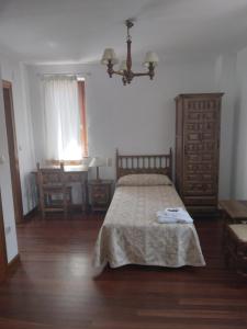 a bedroom with a bed and a table and a chair at Posada San Miguel in RIonansa