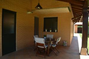 a patio with a table and chairs and a brick wall at Casa Río Tera in Garray