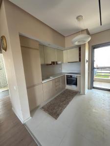 a kitchen with white cabinets and a large window at Lalzi Vacation Apartment in Lalzit Bay +2 photos