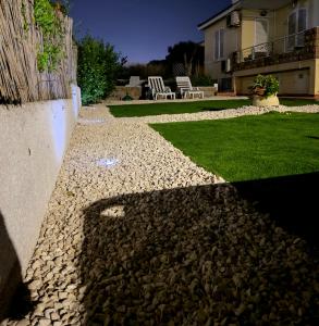 a backyard with a stone walkway and a house at Bed and Breakfast Villa Teis in Quartu SantʼElena