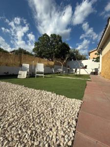 a garden with two chairs and a lawn at Bed and Breakfast Villa Teis in Quartu SantʼElena