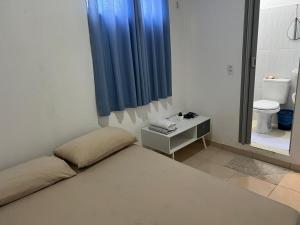 a small room with a bed and a toilet at Quarto Selva in Itaquatiara