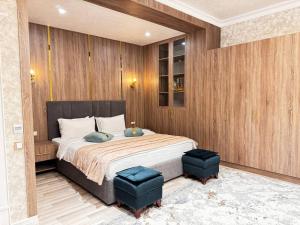 a bedroom with a large bed with two blue ottomans at Silk Road Empire in Samarkand