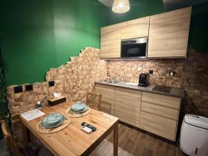 a kitchen with a wooden table and a green wall at JUNGLE SUITE - Jacuzzi - Centre - Clim by Narbana in Narbonne