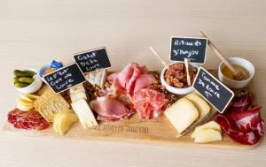 a bunch of different types of food on a cutting board at Chambres d'hôtes "Chez Lyly et Juju" Piscine&Sauna Parking Gratuit in Angers