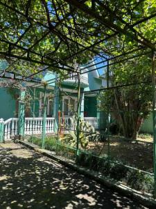 a green fence in front of a house at Дом для отпуска в Гонио in Gonio