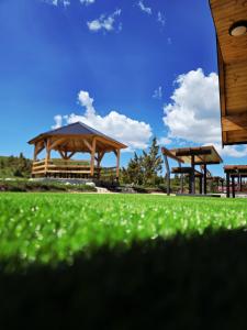 two wooden gazebos in a park with green grass at 4 BEARs in Kovačka Dolina