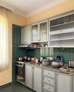 a kitchen with white cabinets and a stove top oven at Дом для отпуска в Гонио in Gonio