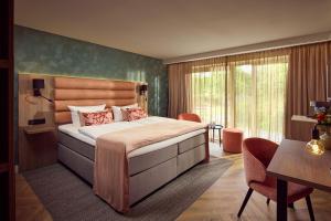 a bedroom with a large bed and a table and chairs at Hotel Gladbeck van der Valk in Gladbeck +56 photos