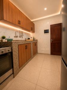 a large kitchen with wooden cabinets and a stove at Djess service in Abidjan