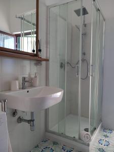 a bathroom with a sink and a glass shower at Casa Bettina in Pizzo