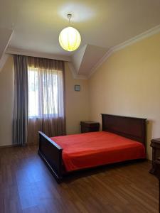 a bedroom with a large bed with a red blanket at Дом для отпуска в Гонио in Gonio