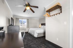 a bedroom with a bed and a ceiling fan at The Lodge at Arrow Lakes in Nakusp +14 photos