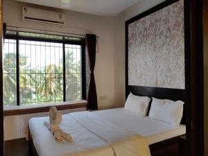 a bedroom with a bed with a stuffed animal on it at The Alibag Beach hotel- Grantley in Alībāg
