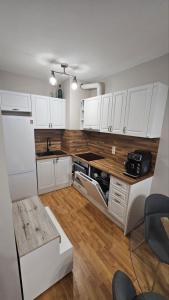 a kitchen with white cabinets and a wooden counter top at Elena Relax Apartment in Varna City