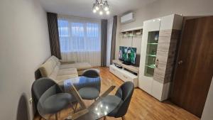 a living room with a couch and a table and chairs at Elena Relax Apartment in Varna City +7 photos