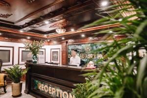 a bar in a restaurant with a man in a mirror at Doris Luxury Hotel in Hanoi