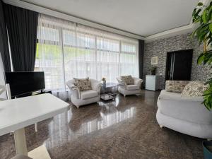 a living room with two couches and a tv at Panoramic Mountains Hotel Guba in Qırızdǝhnǝ