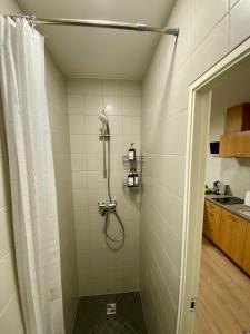 a shower with a shower curtain in a bathroom at Acapulco Liepaja in Liepāja