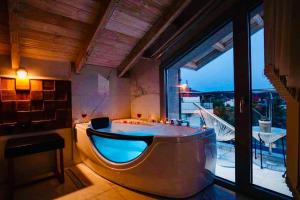 a large bathroom with a tub with a large window at Lena Apartments Potos Thassos in Potos