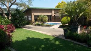 a house with a yard with a swimming pool at Rita's Guesthouse CC in Vryheid