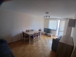 a living room with a table and chairs and a television at Mieszkanie Piaskowa 22 in Kraśnik