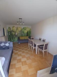 a dining room with a table and chairs and a painting at Mieszkanie Piaskowa 22 in Kraśnik +3 photos