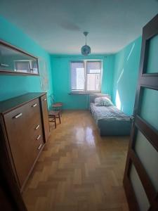 a bedroom with a bed and a dresser and a window at Mieszkanie Piaskowa 22 in Kraśnik