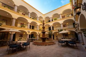 an indoor courtyard with a fountain and tables and chairs at Las Villas Hotel & Golf By Estrella del Mar in Mazatlán
