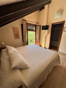 a bedroom with a large white bed with a window at Hotel Rural Huerta del Laurel in Monachil +72 photos