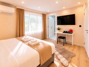 a bedroom with a bed with a desk and a television at Casa Florya Suites in Istanbul