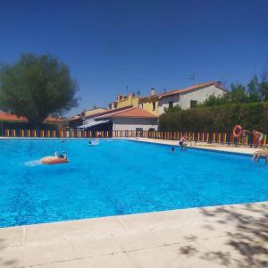 a large blue swimming pool with people in it at Casa rural en Buendía -la Galera con 4 dormitorios in Buendía