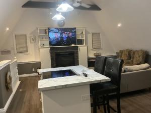 a living room with a tv and a table with chairs at Granary Guest House in Goderich