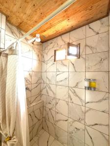 a bathroom with a white marble wall at Chakiñan Hospedaje & Eventos - Tumbaco in Tumbaco