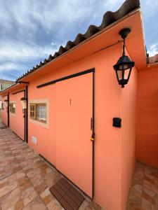 an orange building with a door and a street light at Chakiñan Hospedaje & Eventos - Tumbaco in Tumbaco